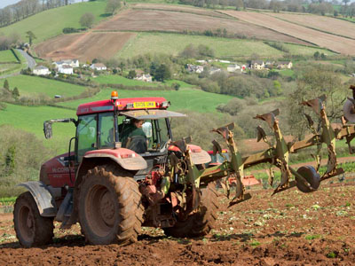 A tractor ploughing a steep field